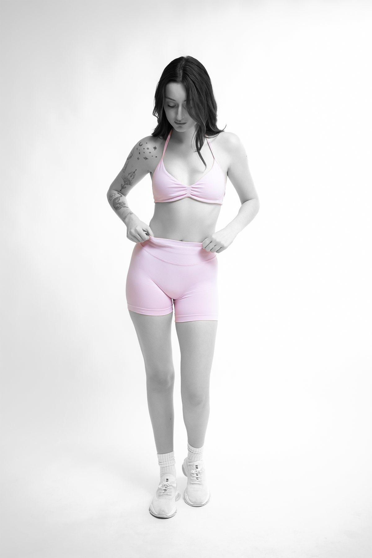 Activewear product detail — adjusting the high-waist band of pink seamless shorts, Melbourne