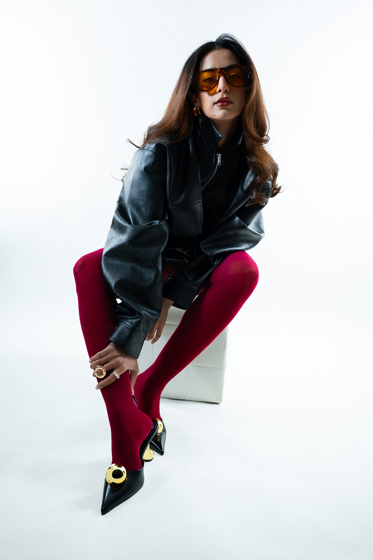 Studio fashion portrait — seated editorial, red tights and leather, Melbourne studio