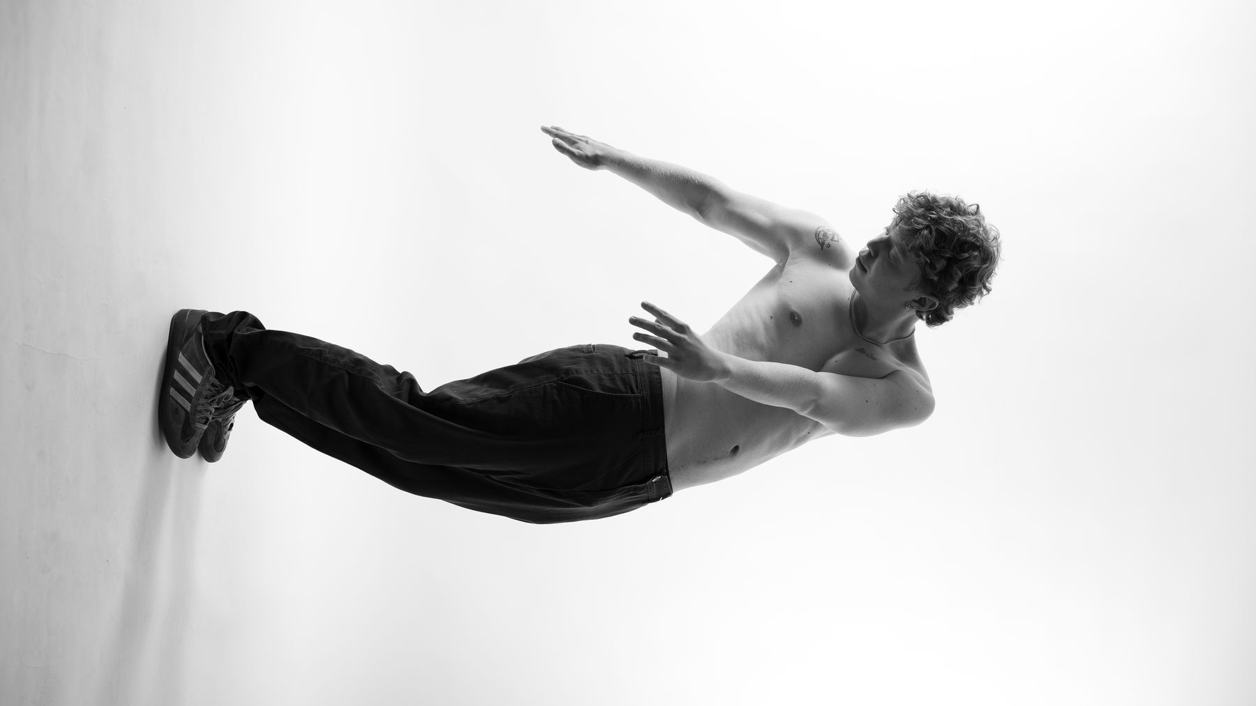 Studio editorial portrait — black and white, suspended horizontal pose, Melbourne studio