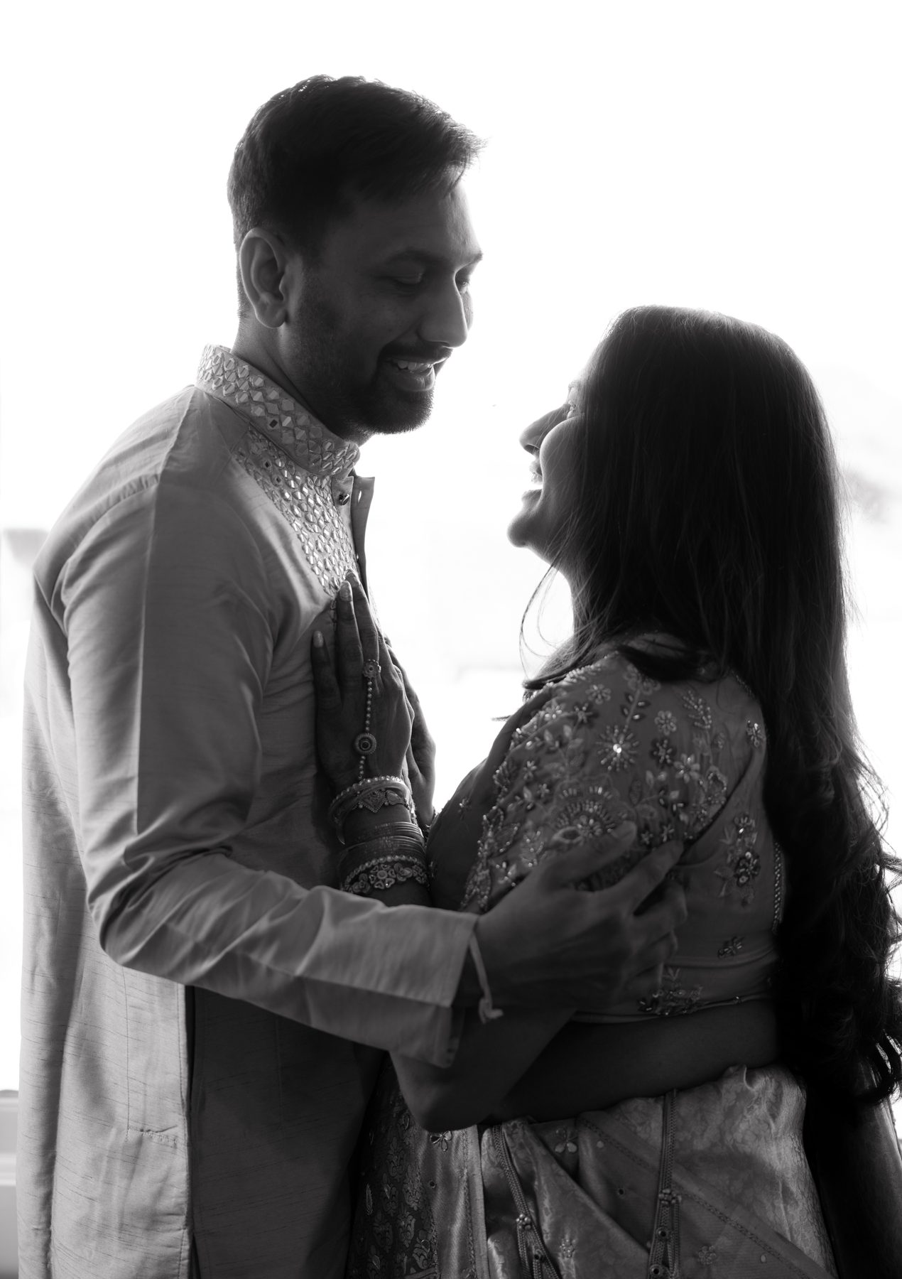 Black and white — couple laughing together against a bright window — maternity photography Melbourne