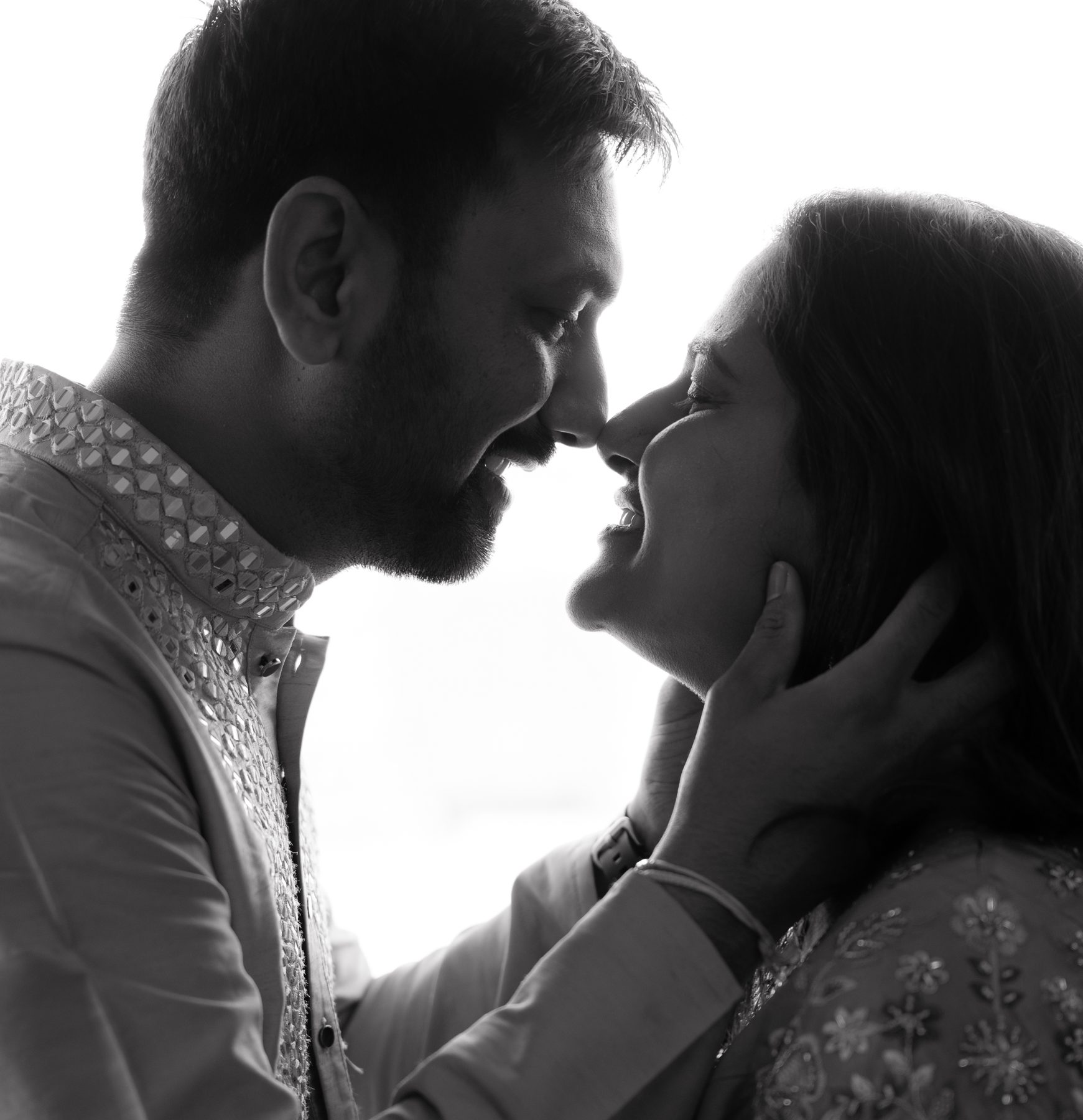 Black and white silhouette — couple nose to nose, laughing, against a bright window — maternity photography Melbourne