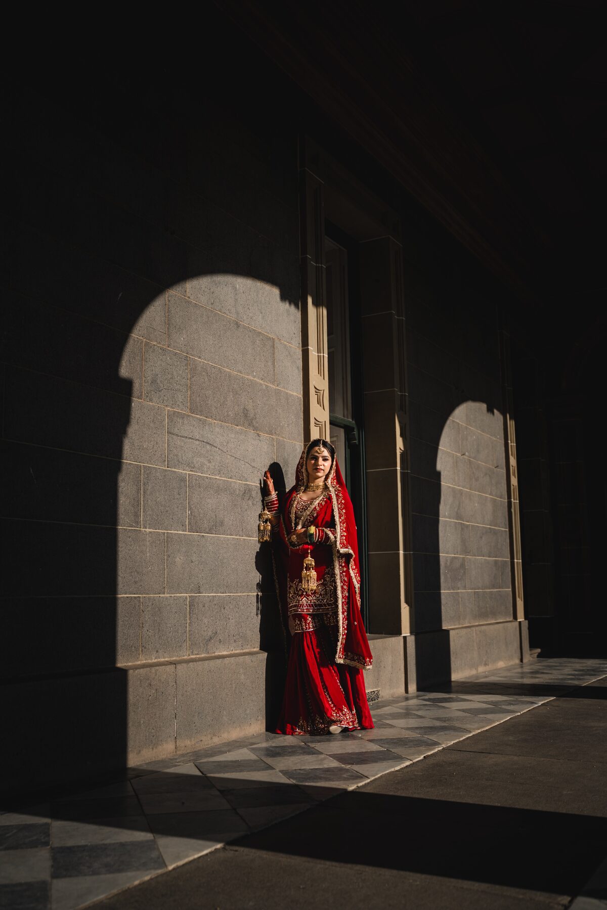 Gradient — bride in dark archway shadow, editorial wedding portrait
