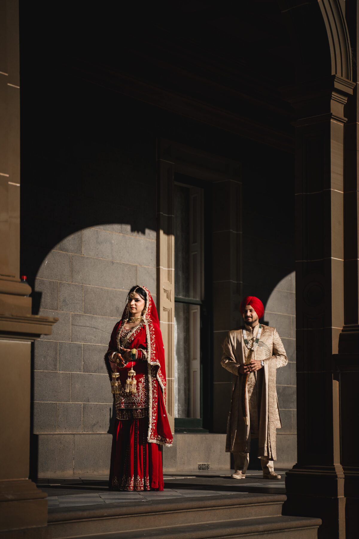 Gradient — bride and groom in dramatic archway, Sikh wedding Melbourne