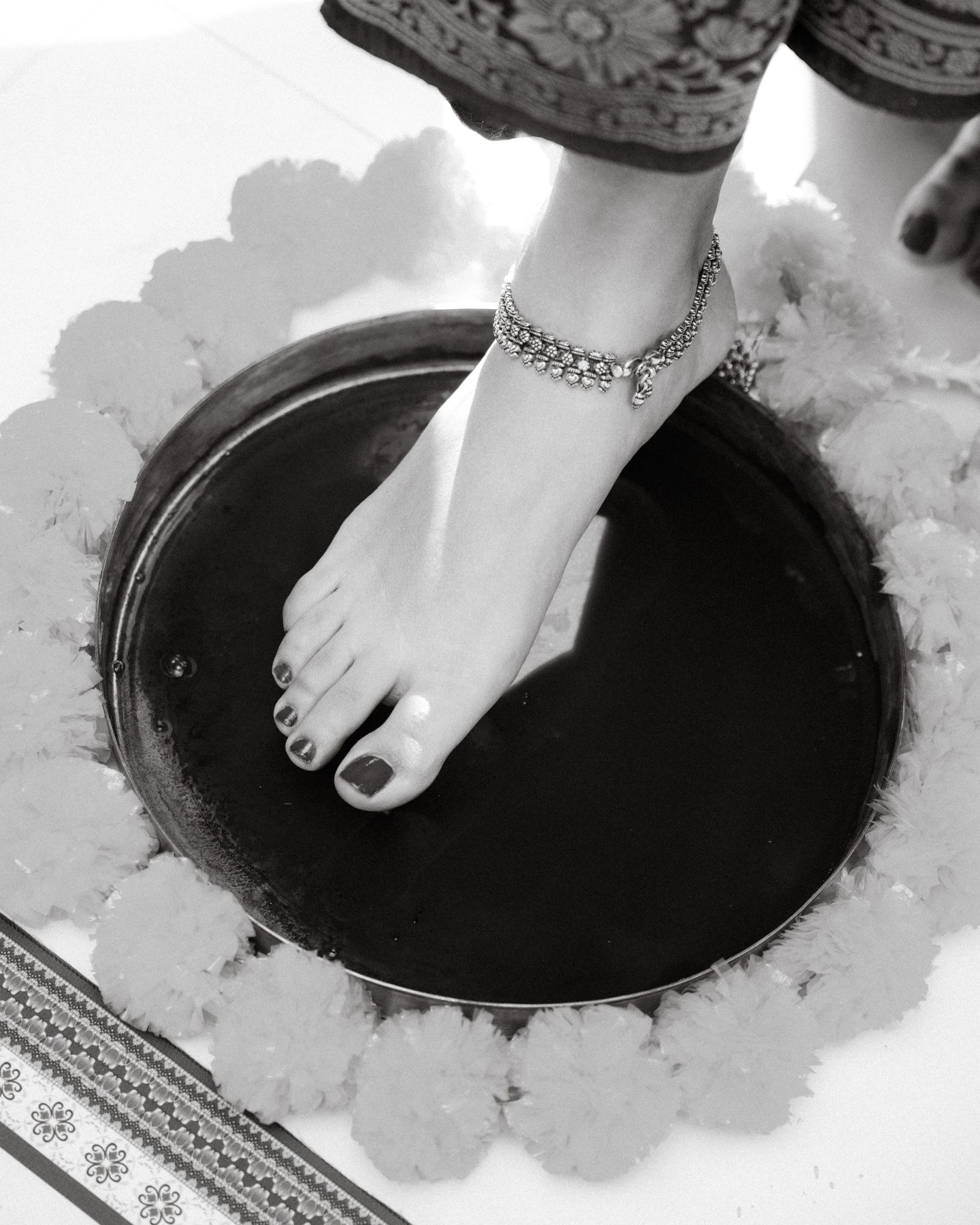 Black and white — foot with anklet on a ceremonial plate, Griha Pravesh ritual — Melbourne