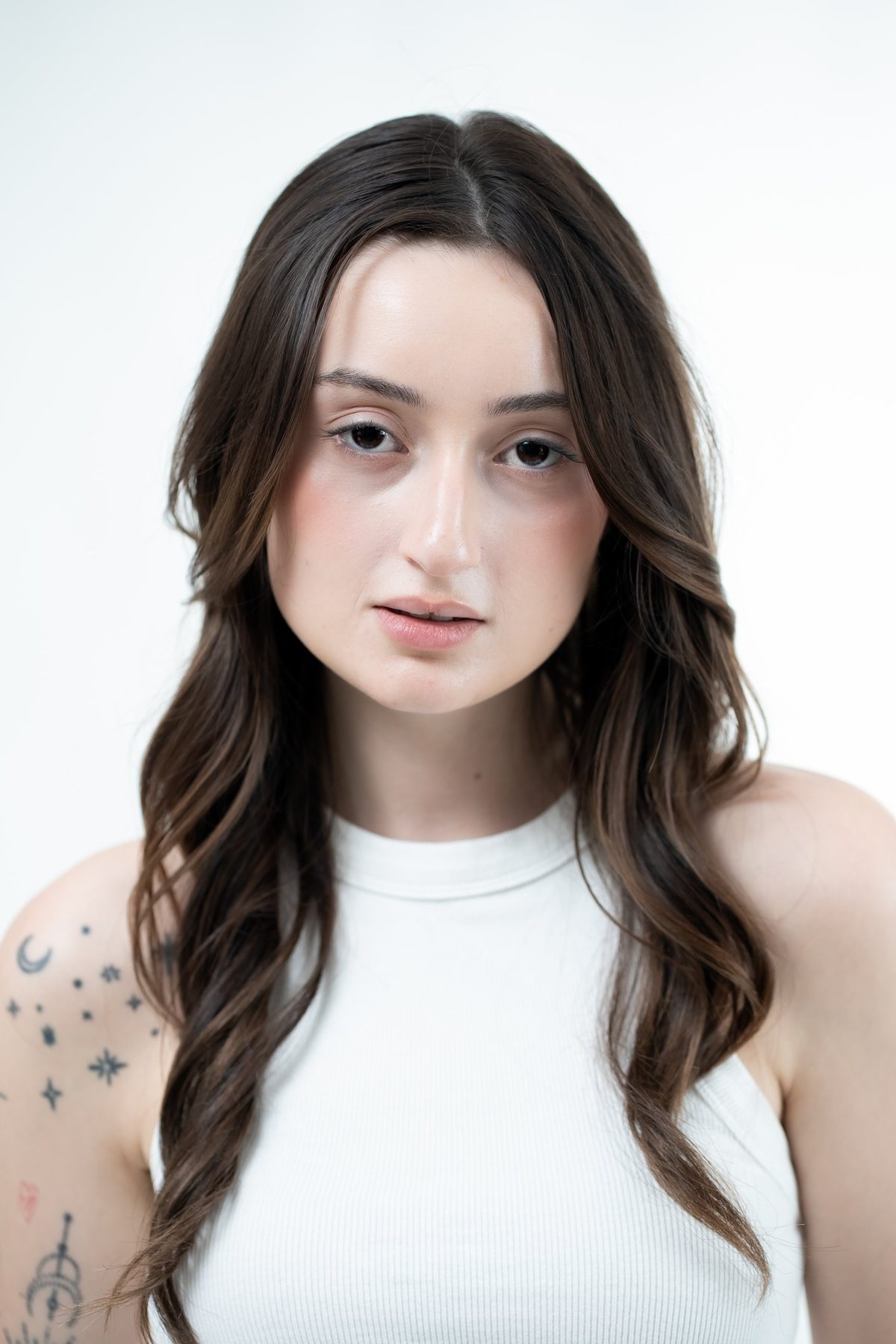 Clean studio headshot on white — long brown hair, natural makeup, direct gaze — model digitals and portfolio photography Melbourne